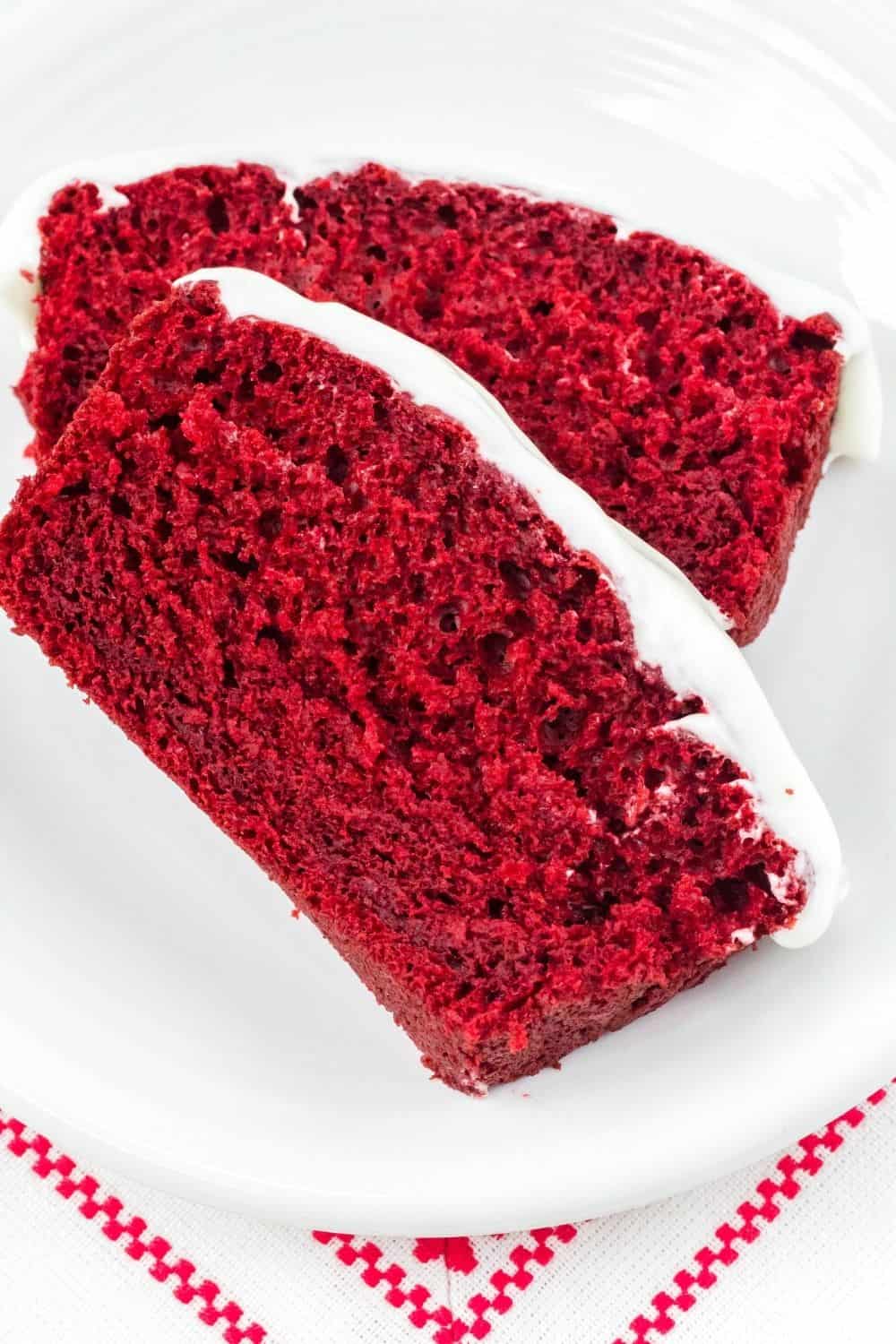 two slices of red velvet loaf cake on a white plate