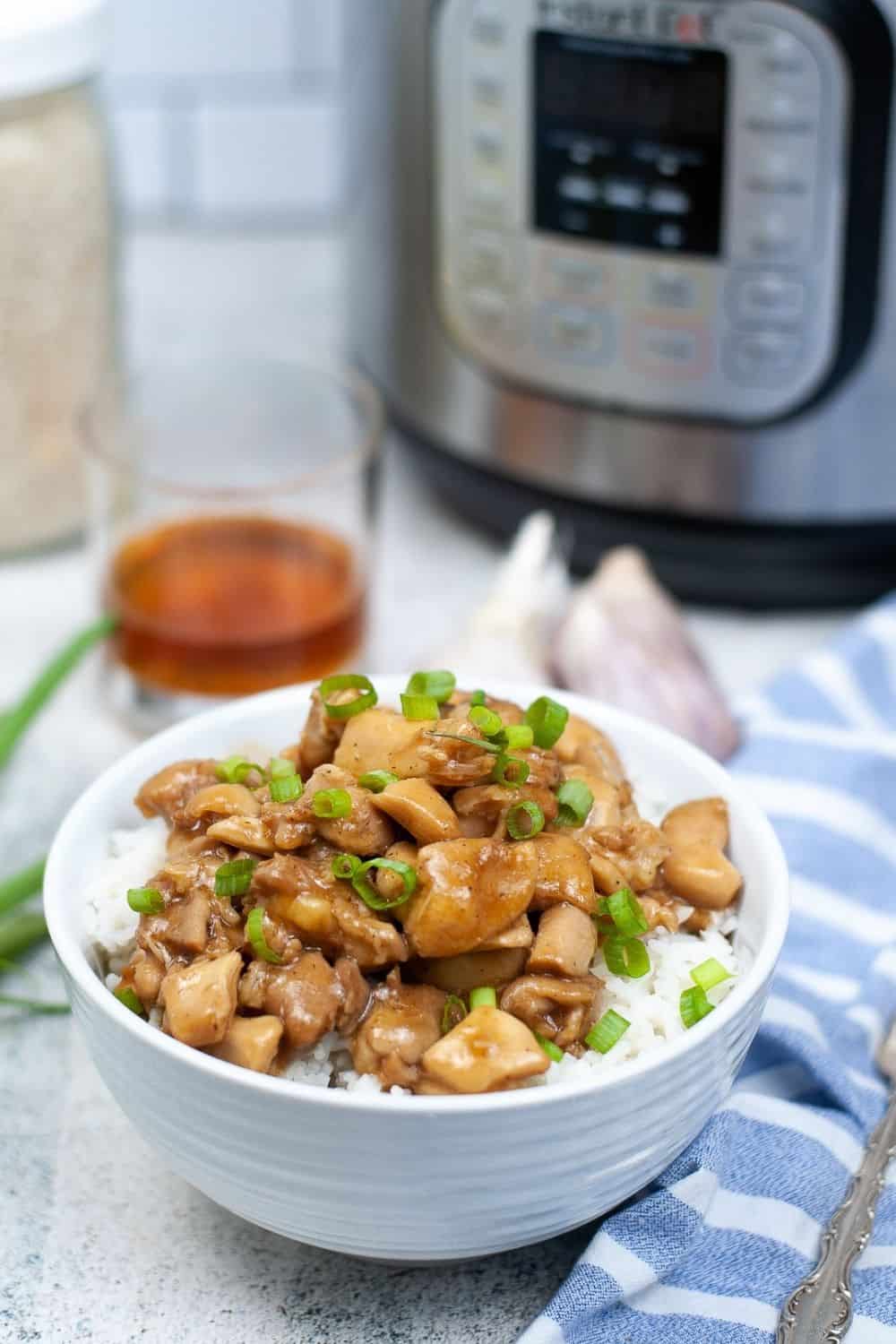 copycat mall food court bourbon chicken cooked in the Instant Pot and served on a bed of rice in a white bowl