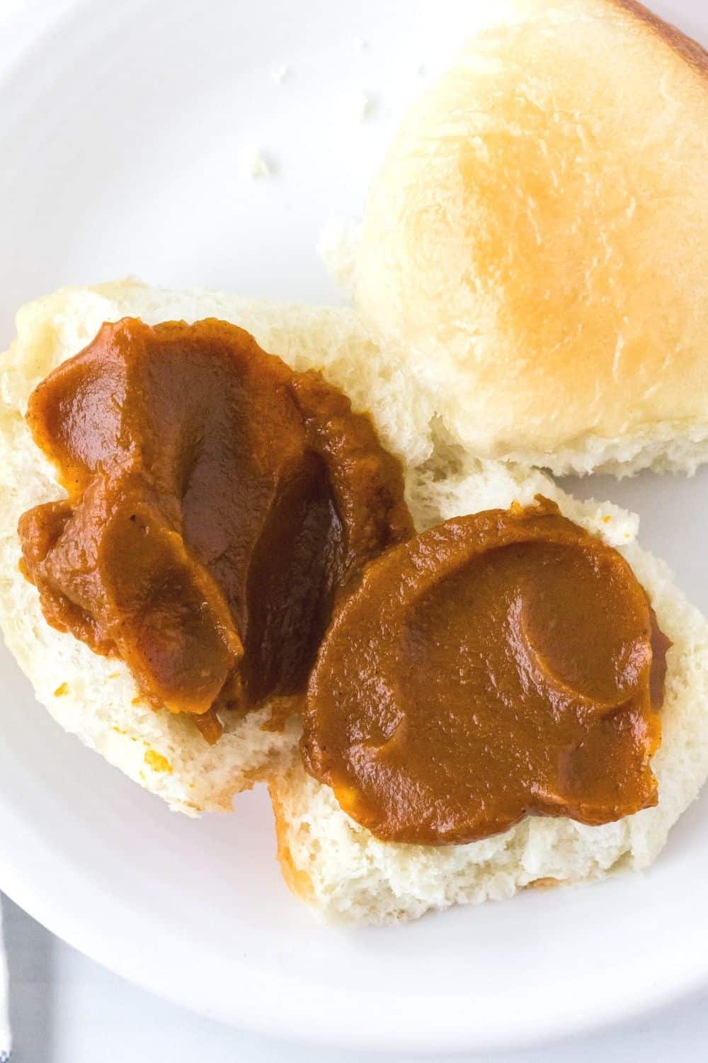 a rhodes roll is split open and spread with pumpkin butter