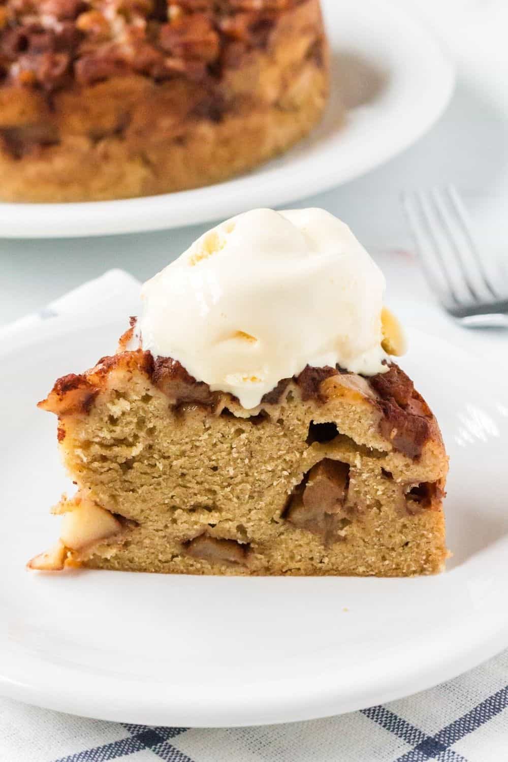 a slice of apple cake cooked in the instant pot served on a white plate, topped with ice cream