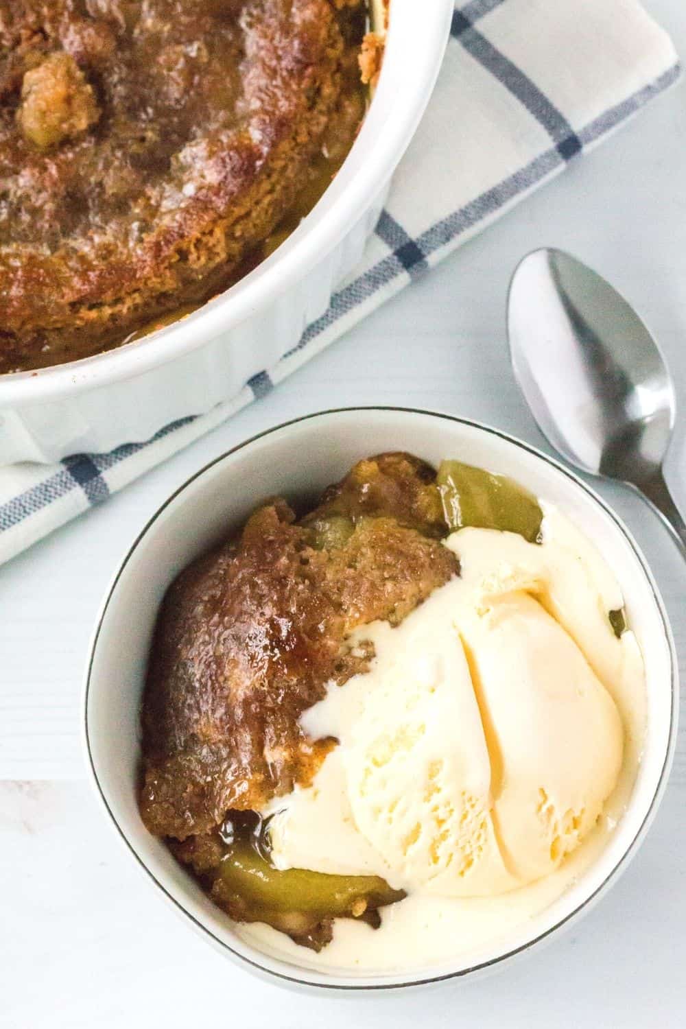 a scoop of vanilla ice cream melts over a serving of apple dump cake cooked in the Instant Pot
