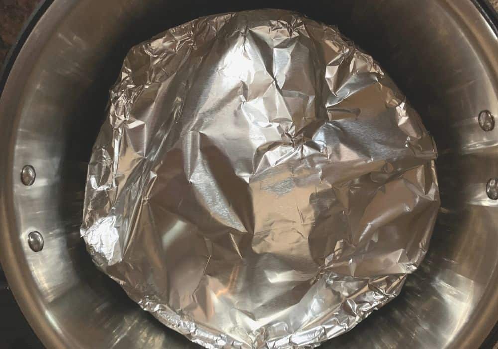 foil covered pan in the instant pot for baking the apple cake