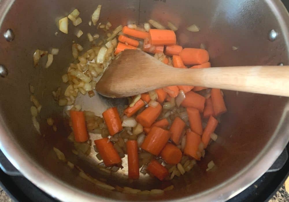 onions and carrots being sauteed in the Instant Pot