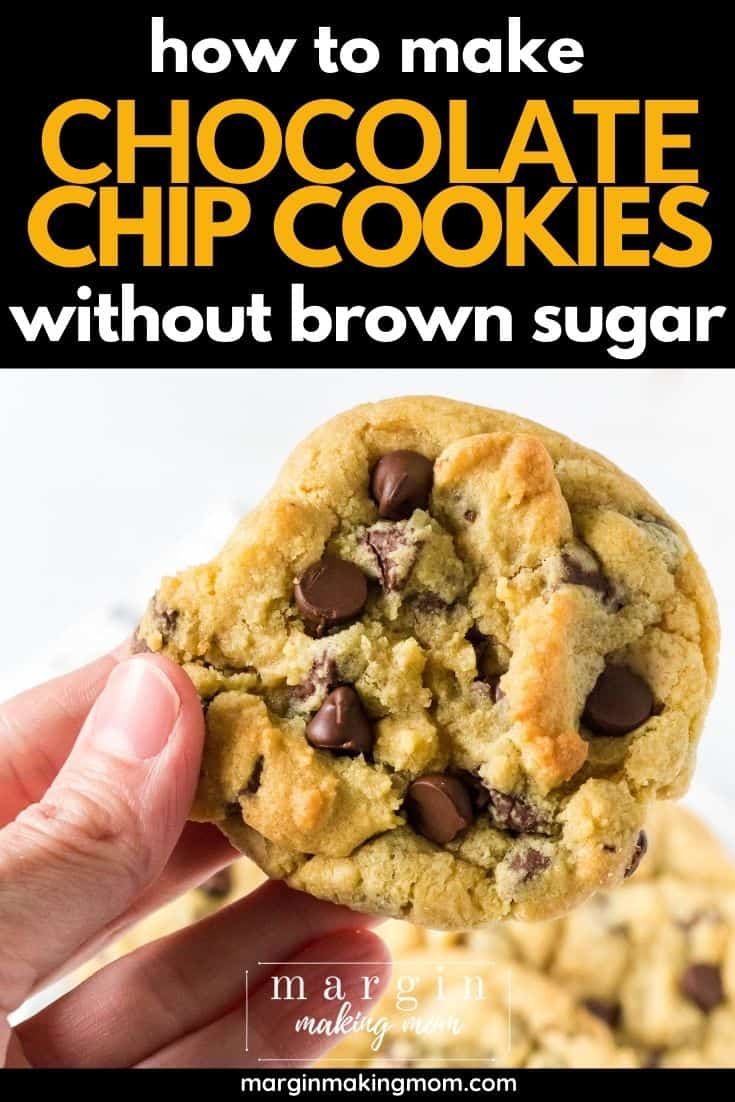 a woman's hand holds a chocolate chip cookie without brown sugar in it