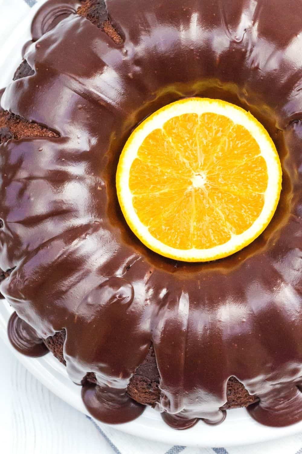 overhead view of a chocolate orange bundt cake, with a halved orange garnish in the center