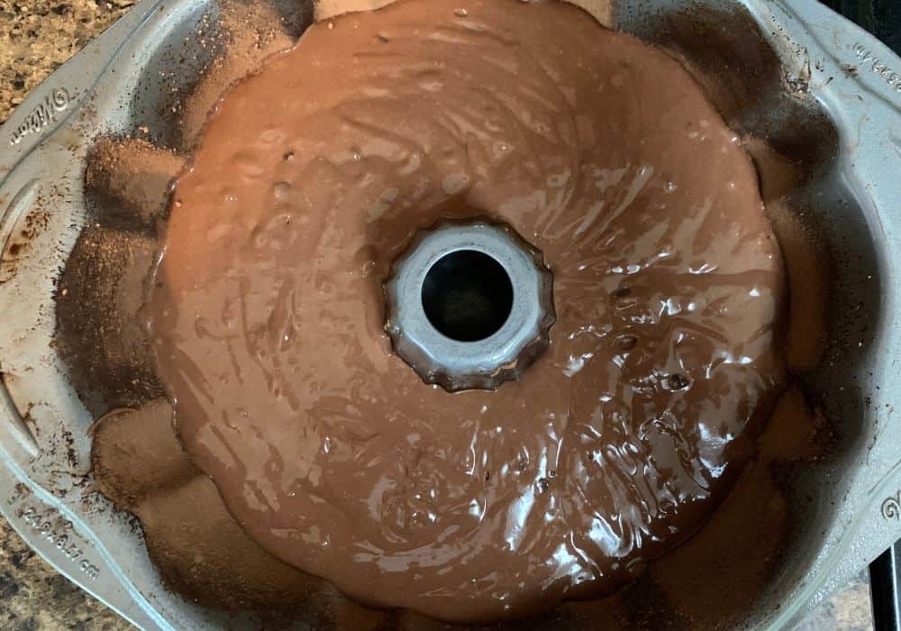 orange chocolate cake batter in prepared bundt pan, ready to be baked