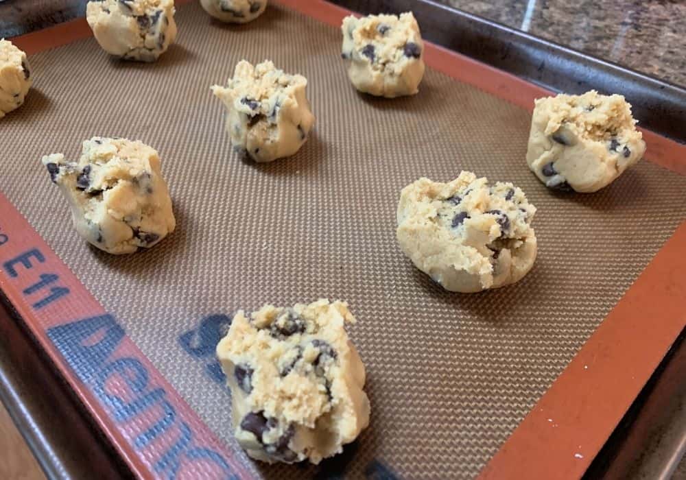 rounds of chocolate chip cookie dough on a baking sheet