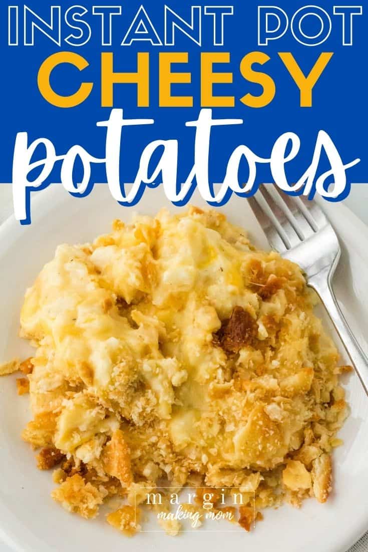 overhead view of a helping of Instant Pot cheesy potatoes on a white plate with a fork next to it