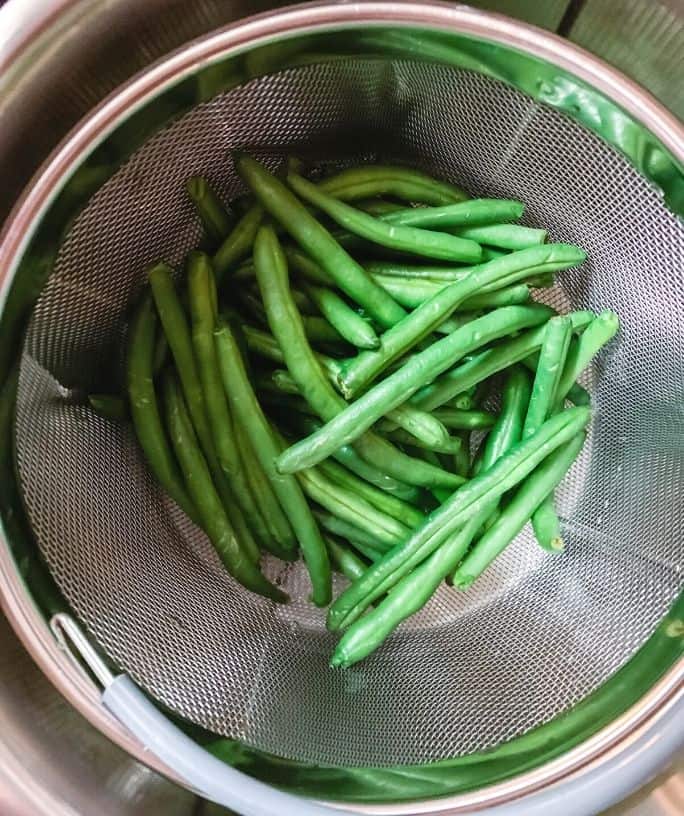 green beans in a steamer basket