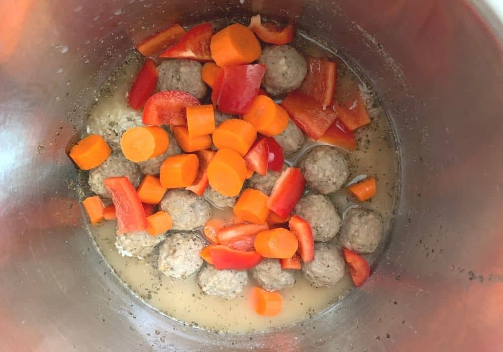 broth, rice, meatballs, carrots, peppers, and seasonings in the Instant Pot