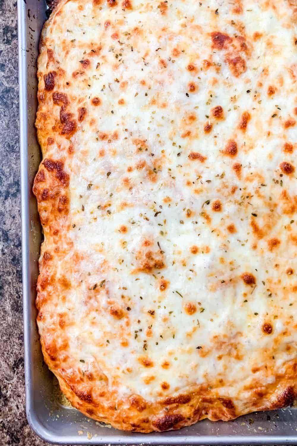 Overhead view of a whole rectangle pizza reminiscent of old-school cafeteria pizza 
