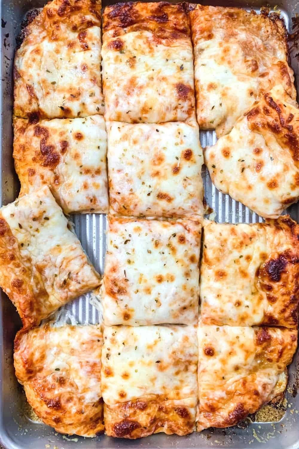 sliced school cafeteria pizza on a jelly roll pan, ready to be served