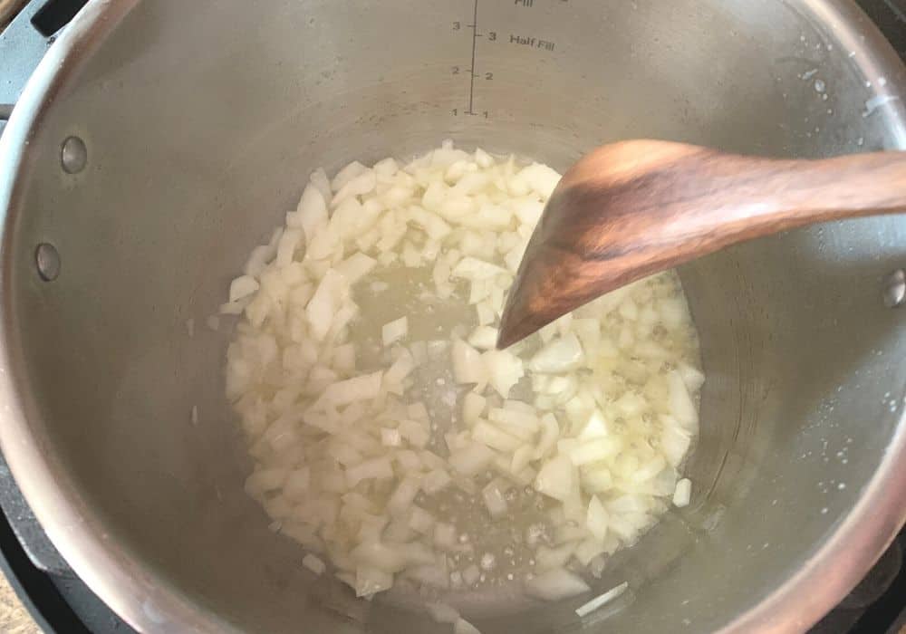 onions being sauteed in the insert pot of the Instant Pot