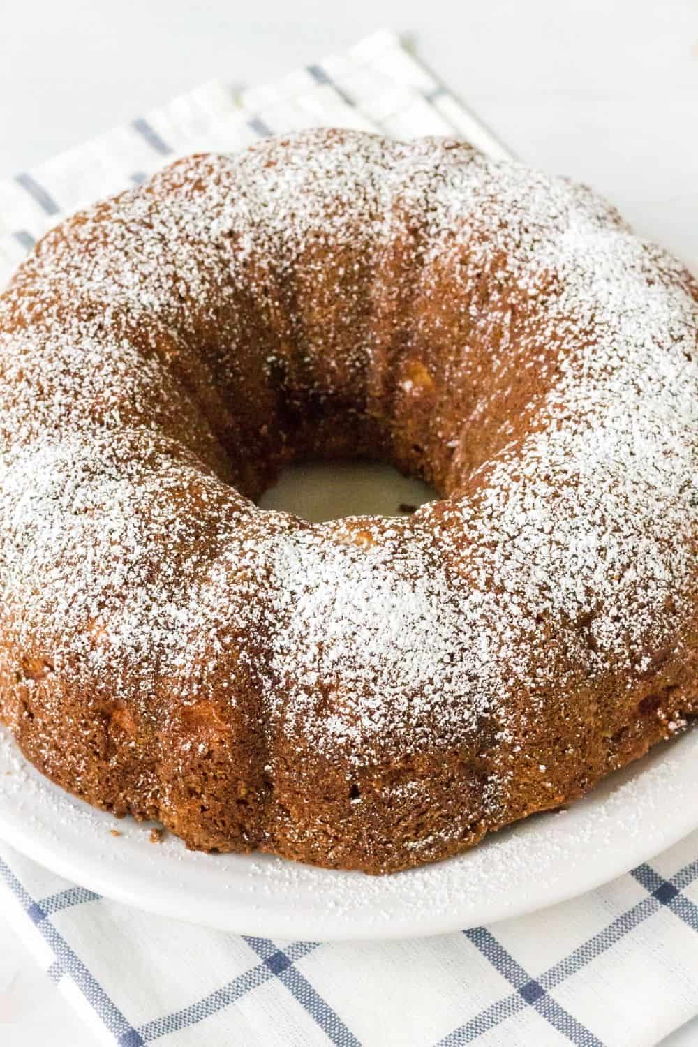 whole pear bundt cake dusted with powdered sugar and served on a white plate