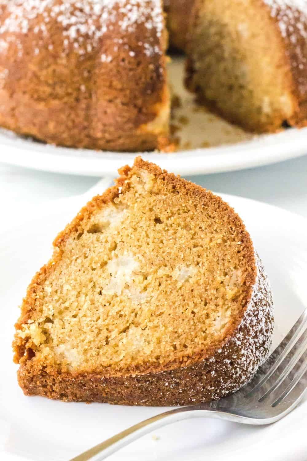 up-close view of a slice of moist pear cake, showing the tender interior dotted with bits of fresh pear