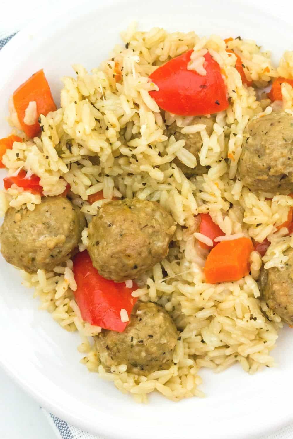 close-up view of meatballs, rice, peppers, and carrots cooked in the Instant Pot, served on a white plate