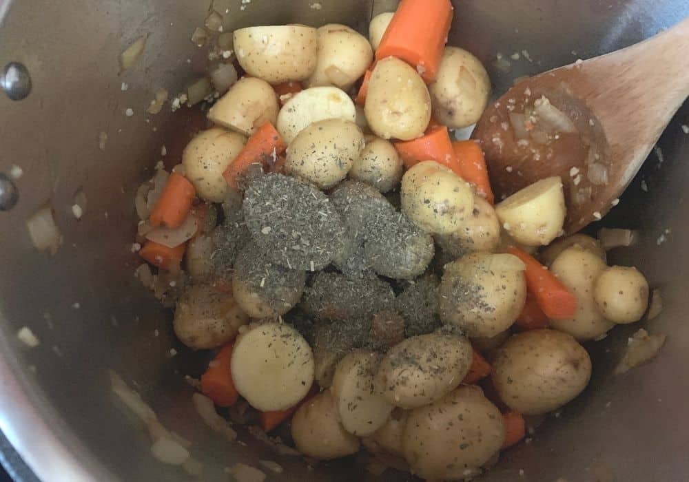 baby gold potatoes, herbs, and seasonings added to the carrots and onions in the Instant Pot