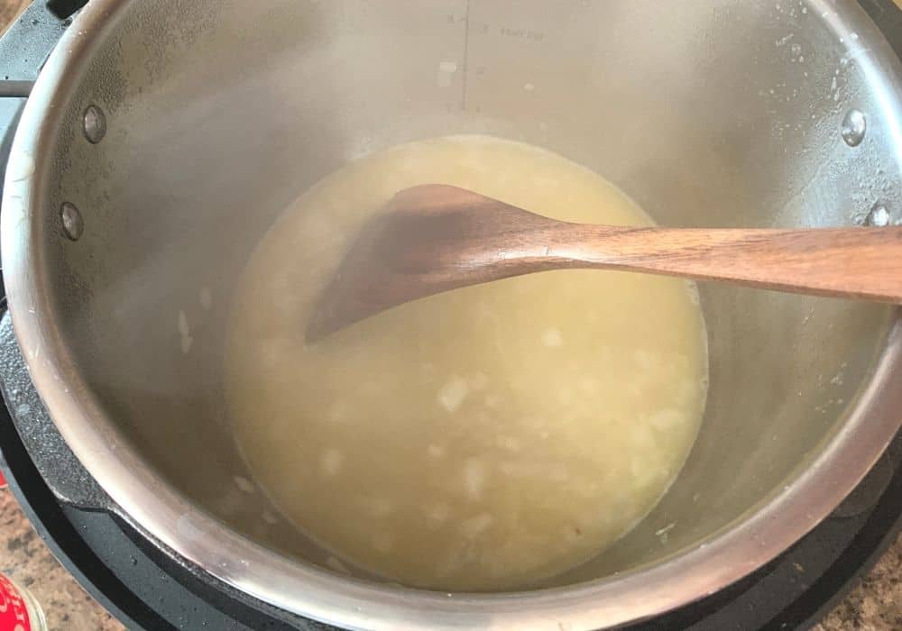 broth added to onions in the insert pot of the Instant Pot