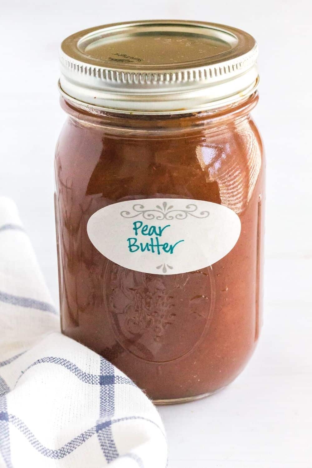a jar of pear butter with a dissolveable label on it that reads "pear butter"