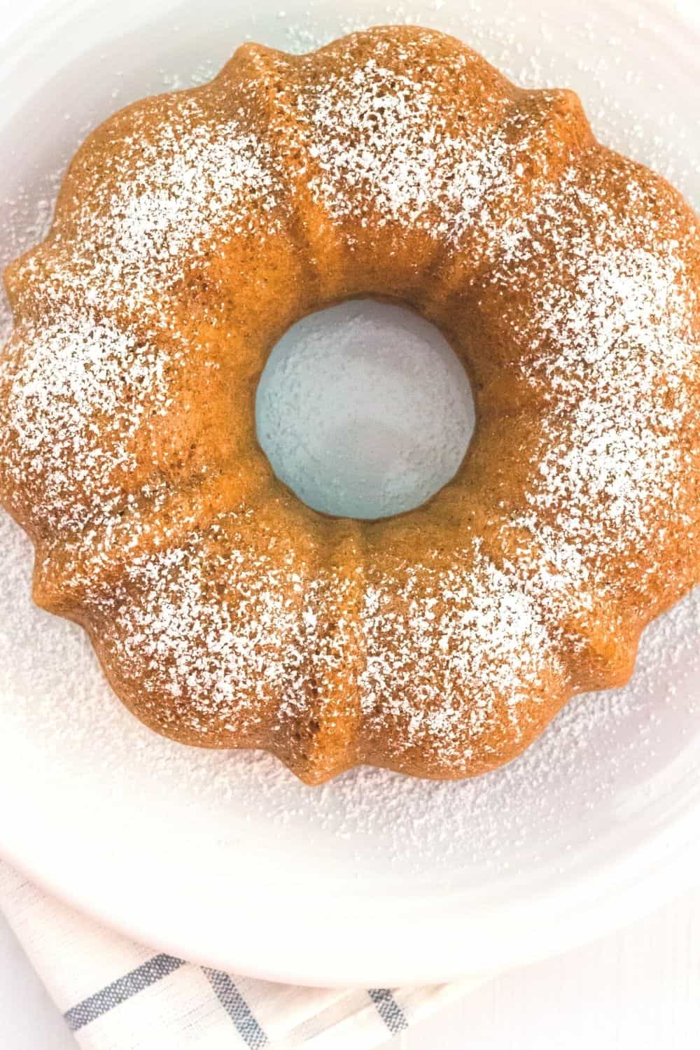 applesauce bundt cake cooked in the Instant Pot pressure cooker, served on a white plate and sprinkled with powdered sugar