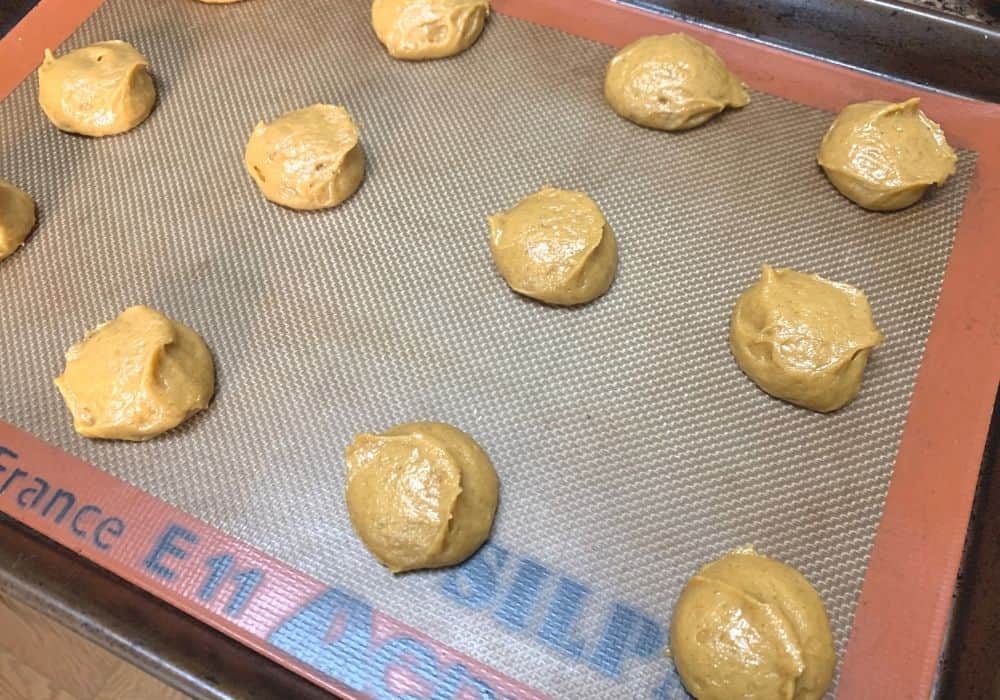 rounds of pumpkin cookie batter on prepared baking sheet