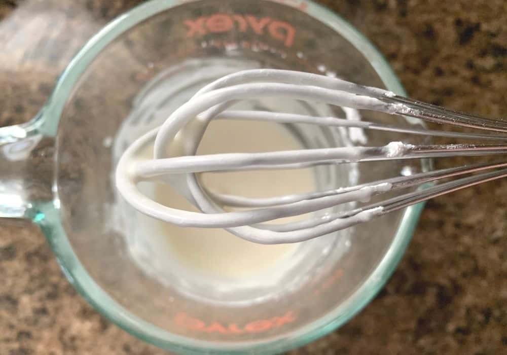a whisk showing the smooth glaze for the scones