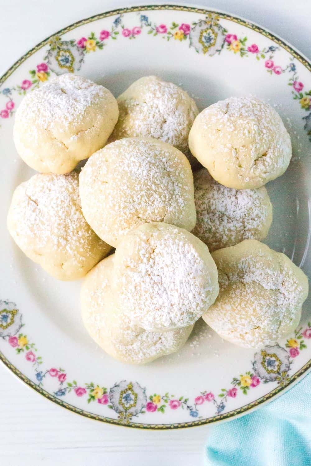 cream cheese cookies dusted with powdered sugar and served on a china plate