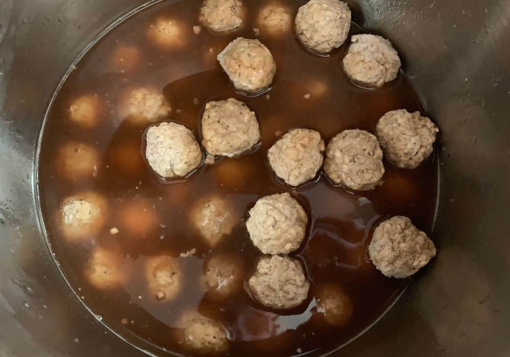 frozen meatballs along with broth and other ingredients for making swedish meatballs in the pressure cooker