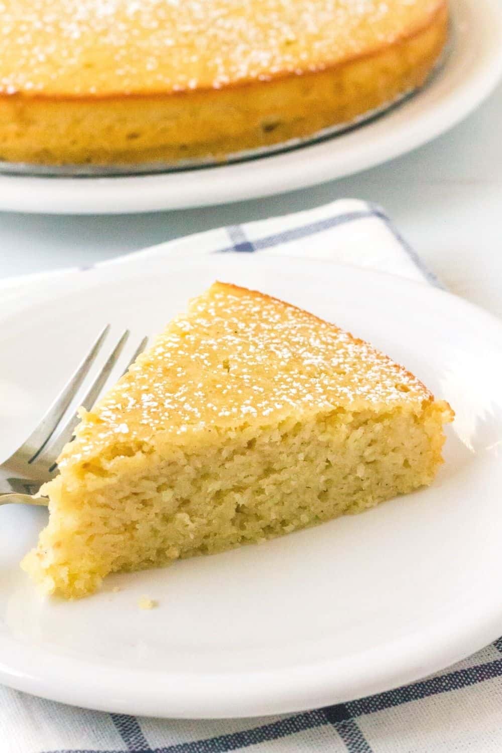 close-up of the moist interior of a slice of pear cake, served on a white plate with a fork next to it