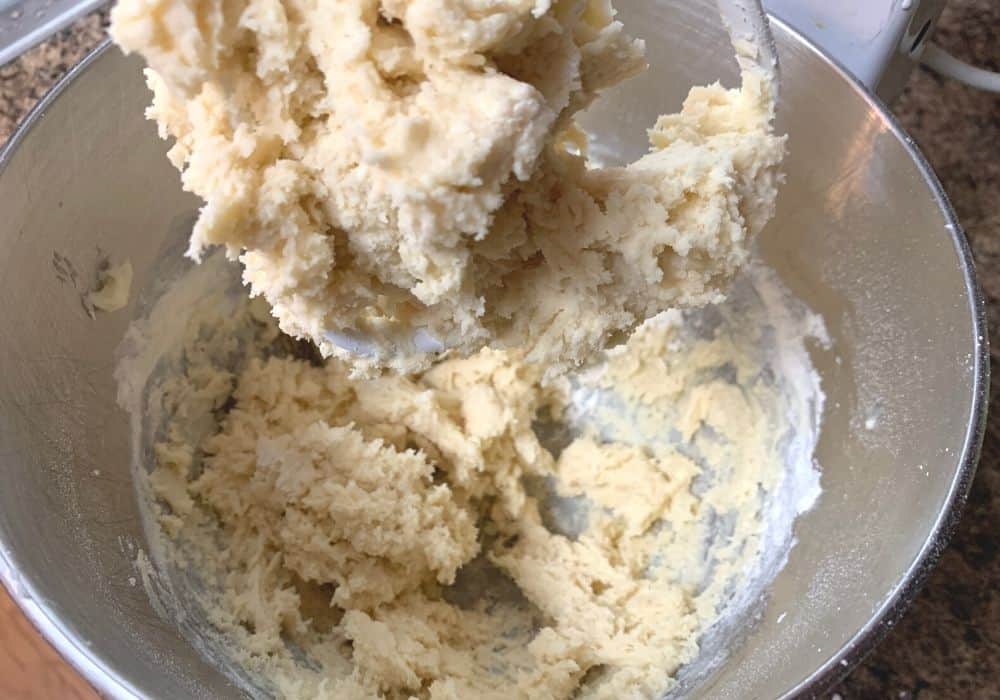 dry ingredients added to the mixing bowl, creating a soft dough for the cream cheese cookies