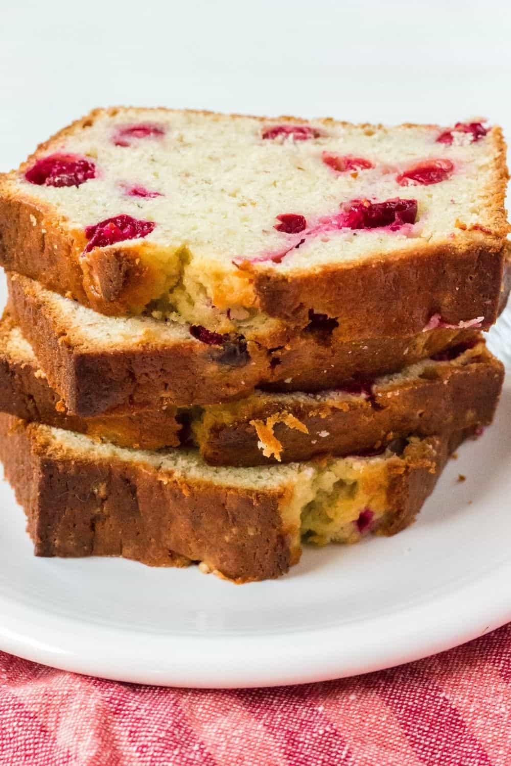 slices of cranberry banana bread stacked on a white plate