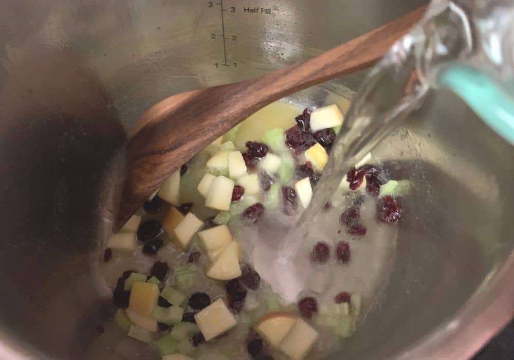 diced apples and cranberries added to the insert pot, along with water for the stuffing.