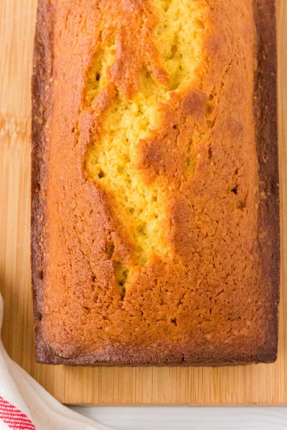 freshly baked loaf of quickbread made with eggnog, on a cutting board