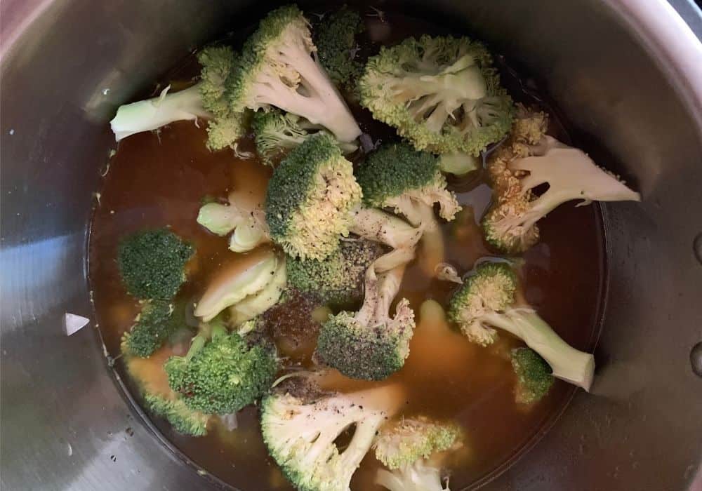 broccoli, broth, and black pepper in the Instant Pot for making broccoli soup.
