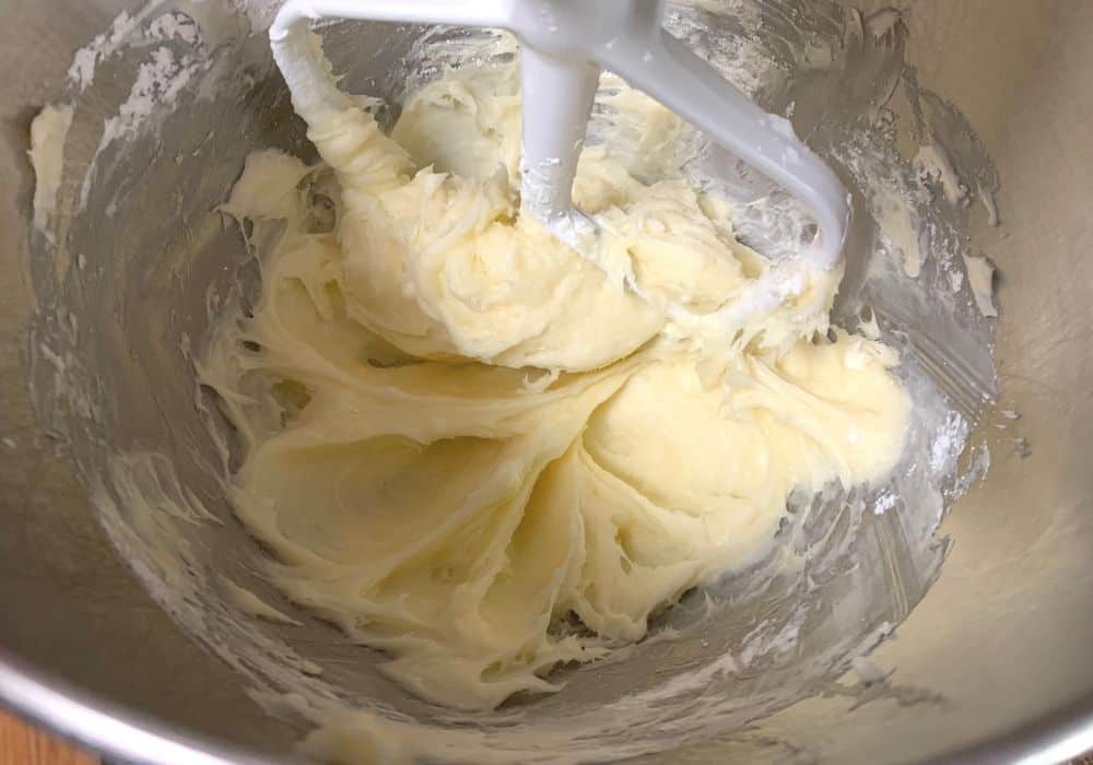 cream cheese, butter, and powdered sugar mixed together in the bowl of a stand mixer
