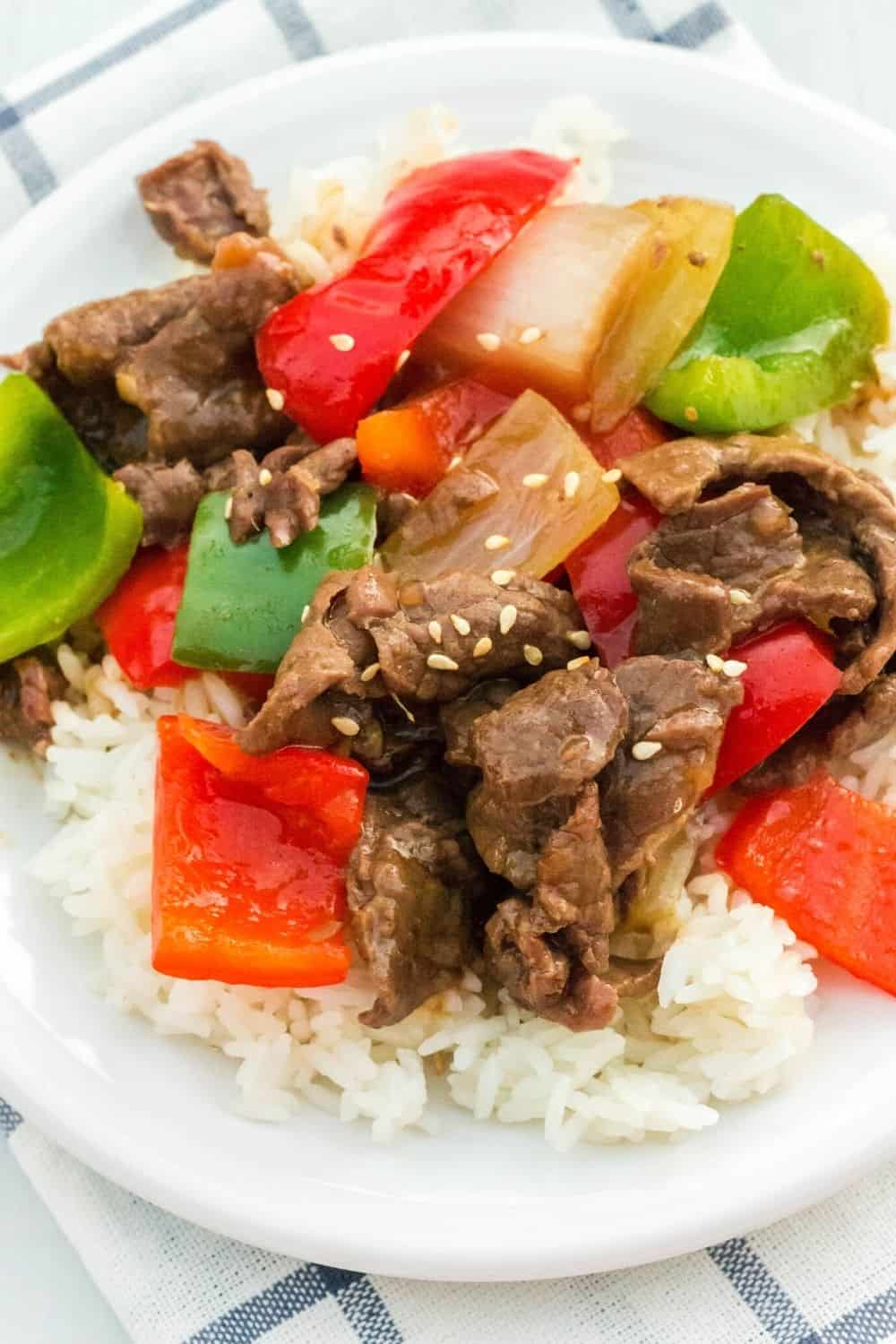 Instant Pot Chinese beef with sauce, along with bell peppers and onions, served over white rice