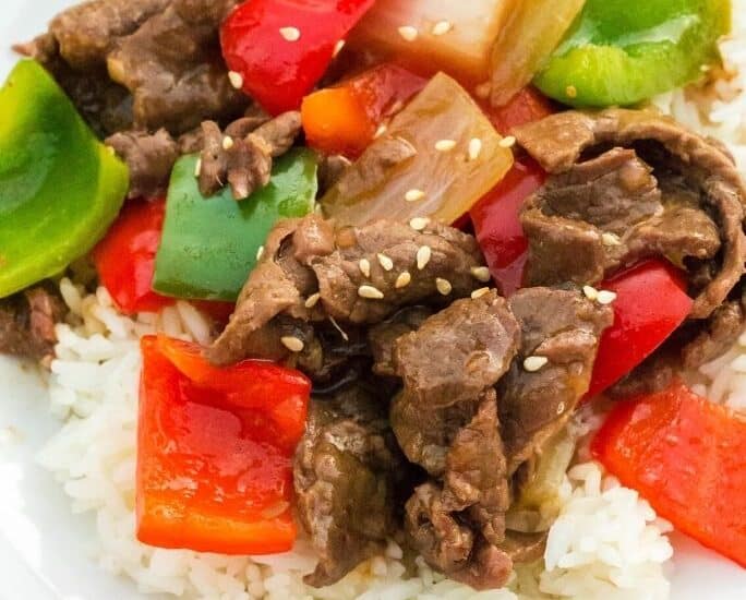 Instant Pot pepper steak served over rice on a white palte