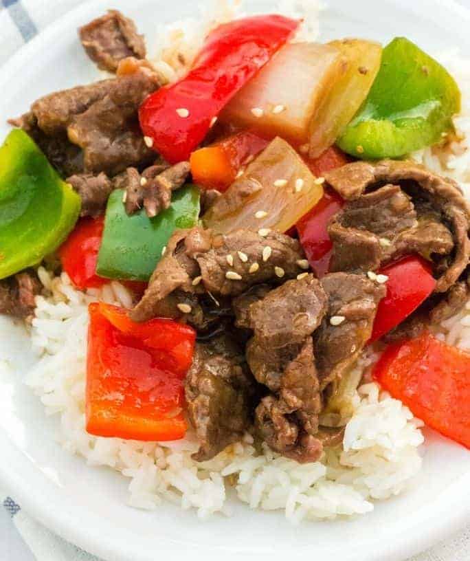 Instant Pot pepper steak served over rice on a white palte