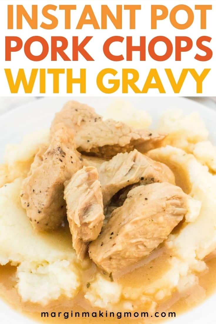 close-up view of Instant Pot pork chops and gravy over mashed potatoes, with the pork chop pulled apart into pieces, showing the moist interior of the meat.