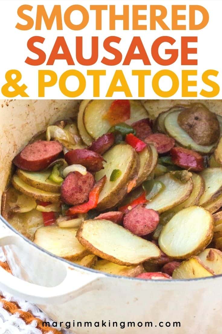 Dutch oven with smoked sausage and potatoes, along with peppers and onions, in it