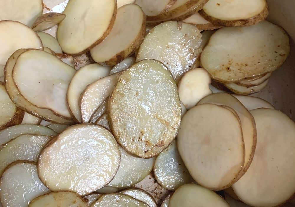 sliced potatoes being cooked in a dutch oven