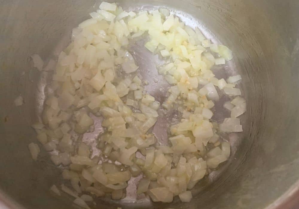onions and garlic cooking in the insert pot of the Instant Pot