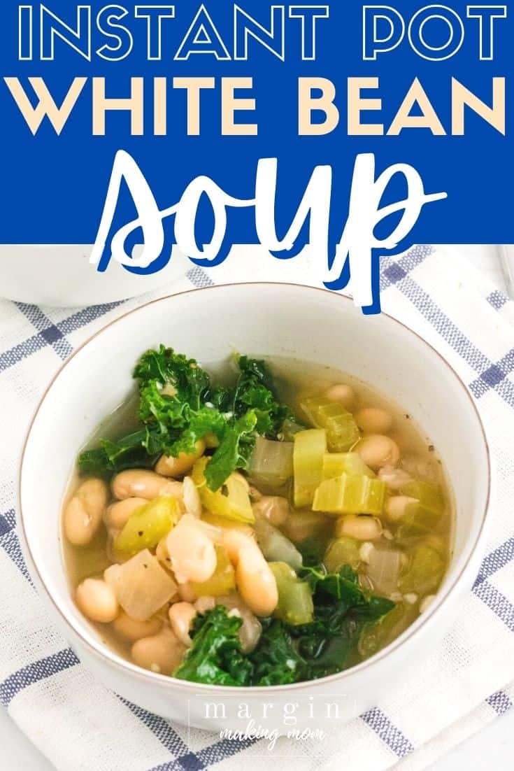 a white bowl with a serving of Instant Pot white bean soup in it, atop a blue and white checked napkin.