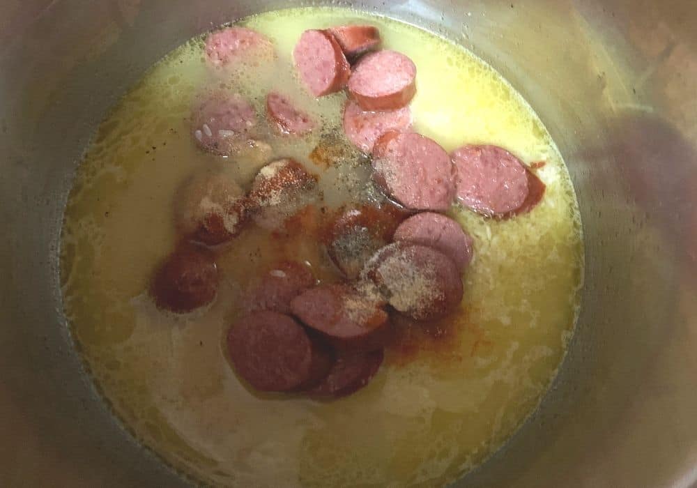 rice, broth, seasonings, and sausage in the insert pot of the Instant Pot