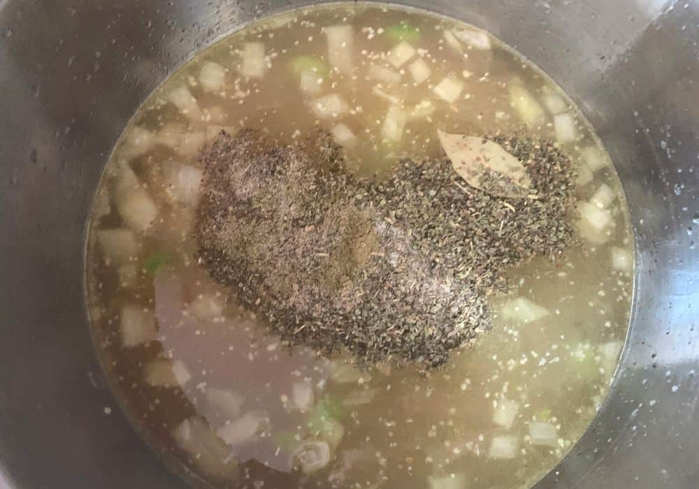 broth, beans, and seasonings added to the insert pot of the Instant Pot prior to pressure cooking the soup.