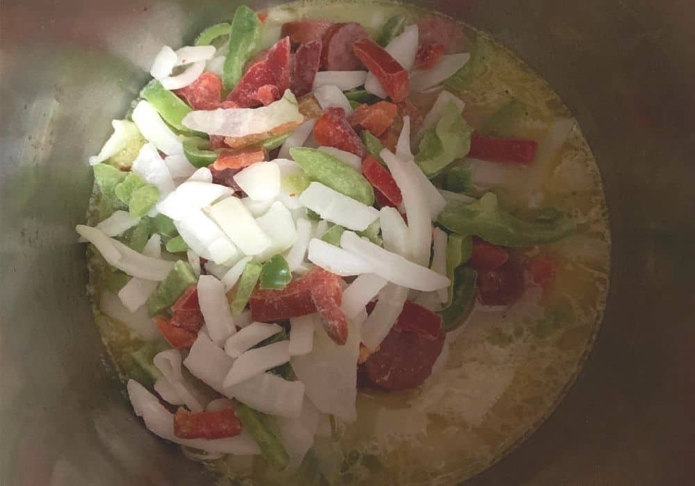 frozen peppers and onions added to the insert pot of the Instant Pot
