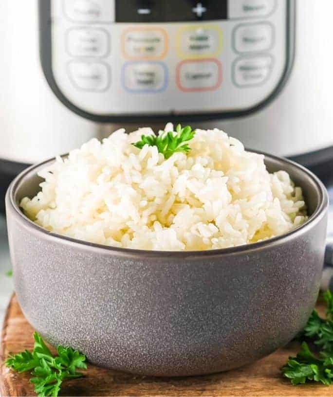 bowl serving Instant Pot long grain white rice in front of the pressure cooker