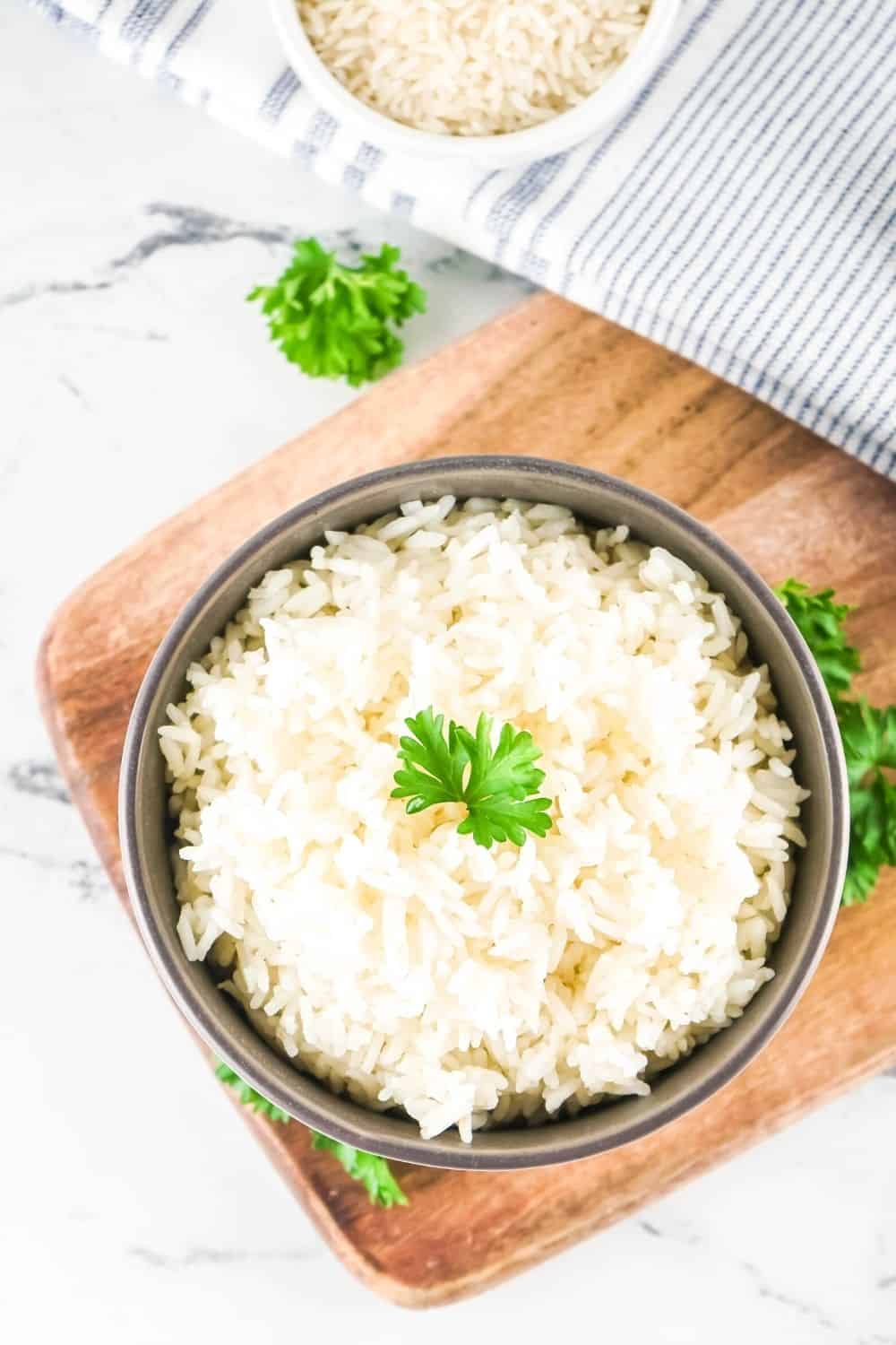 bowl of white rice cooked in the Instant Pot resting on a wooden board