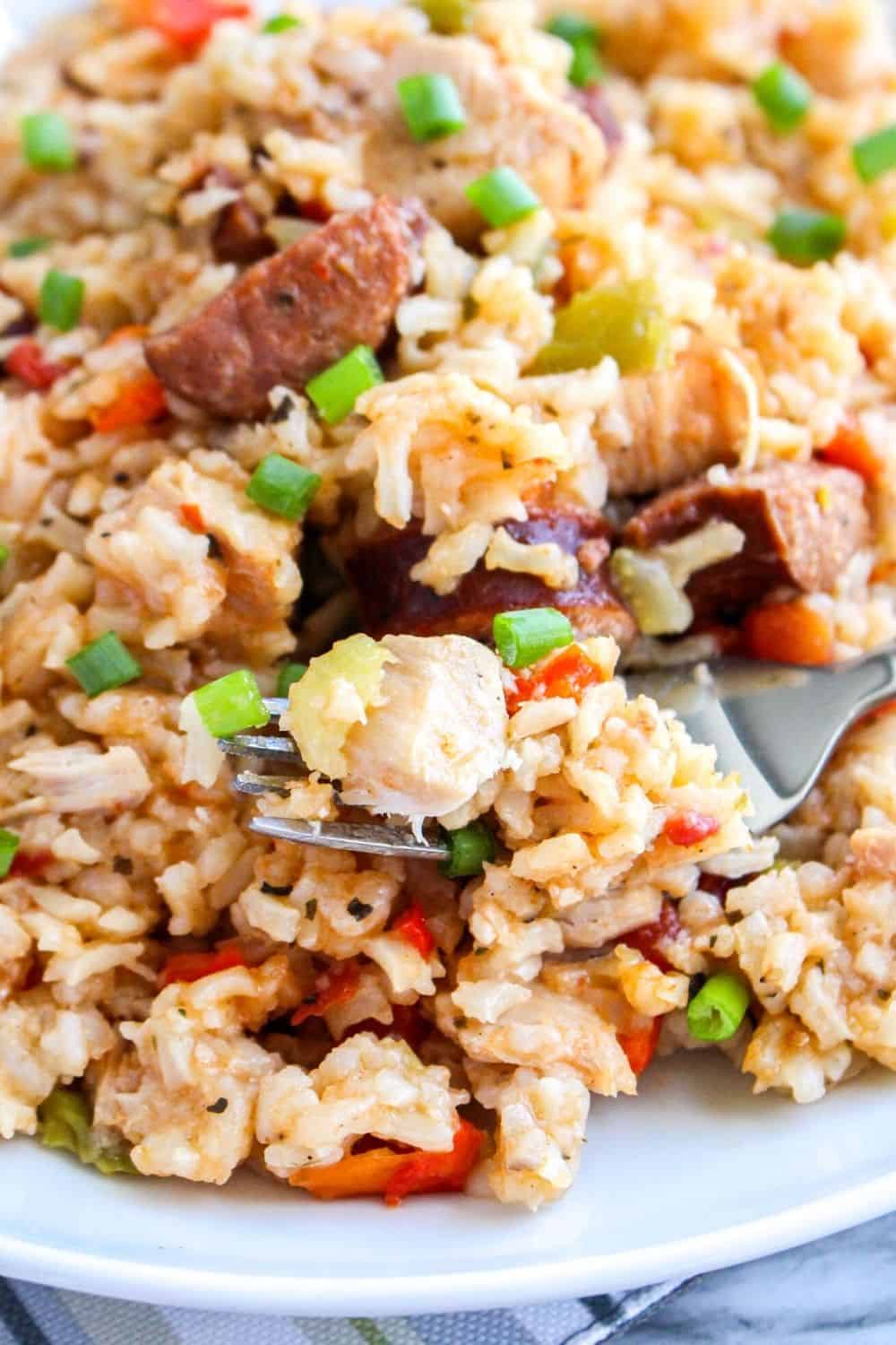 close-up of a fork holding a bite of pressure cooker jambalaya with chicken and sausage