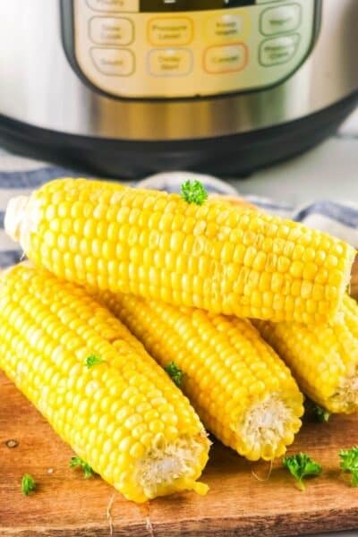 Instant Pot corn on the cob displayed on a wooden cutting board